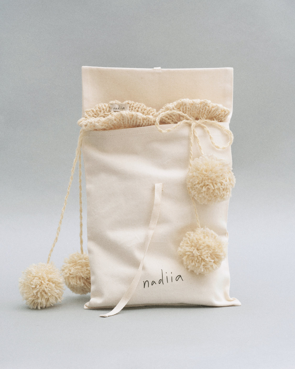Купіть виріб ручної роботи Knee Socks with Pompoms in Milk від Nadiia World. Ідеальний вибір для додавання вишуканості та шарму до вашого житлового простору або колекції особистих аксесуарів.