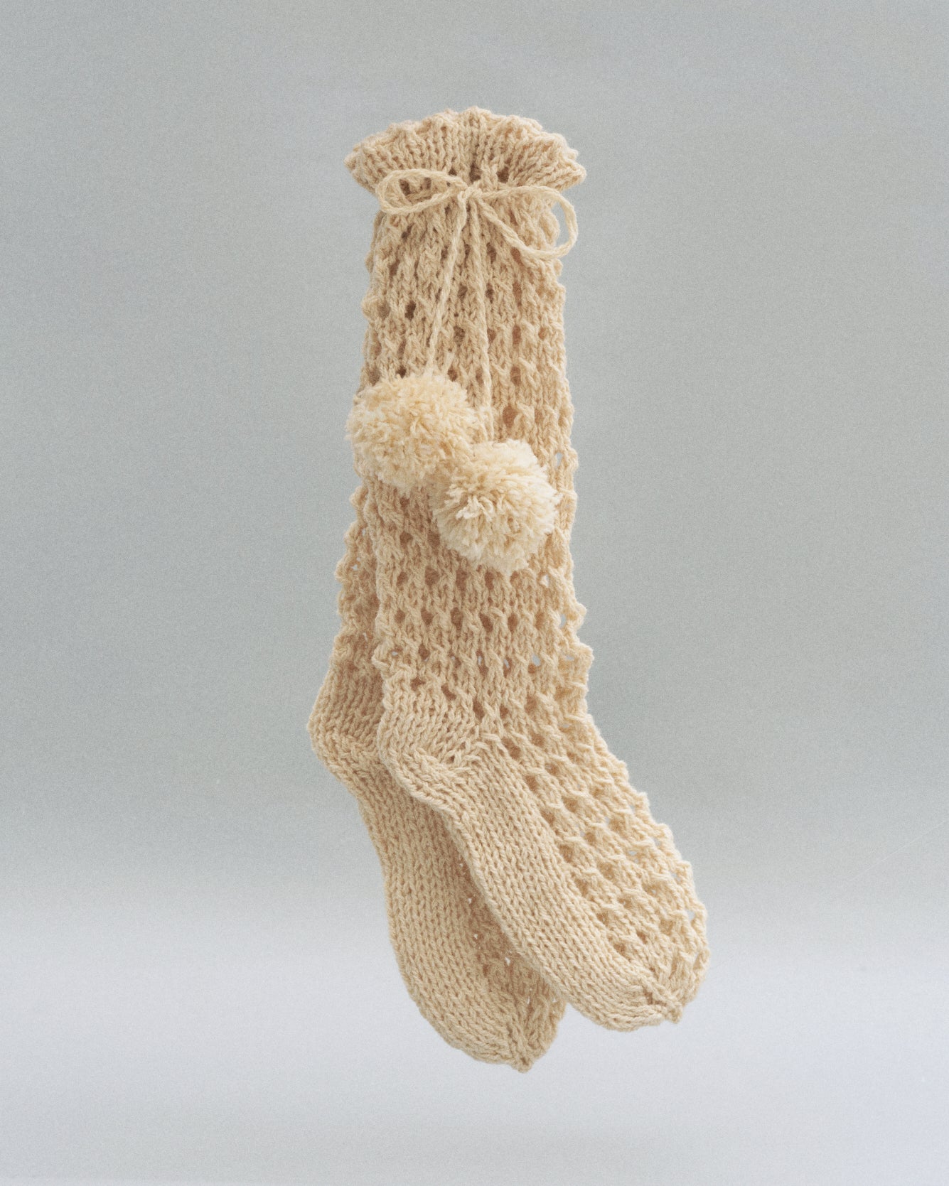 Купіть виріб ручної роботи Knee Socks with Pompoms in Milk від Nadiia World. Ідеальний вибір для додавання вишуканості та шарму до вашого житлового простору або колекції особистих аксесуарів.