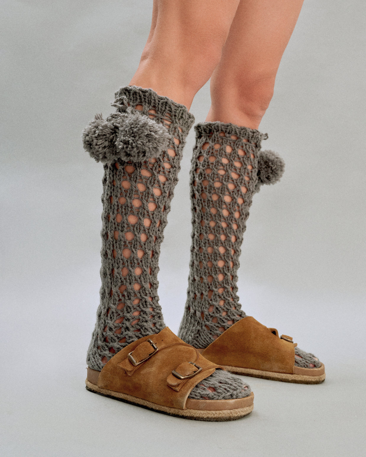 Купіть виріб ручної роботи Knee Socks with Pompoms in Grey від Nadiia World. Ідеальний вибір для додавання вишуканості та шарму до вашого житлового простору або колекції особистих аксесуарів.