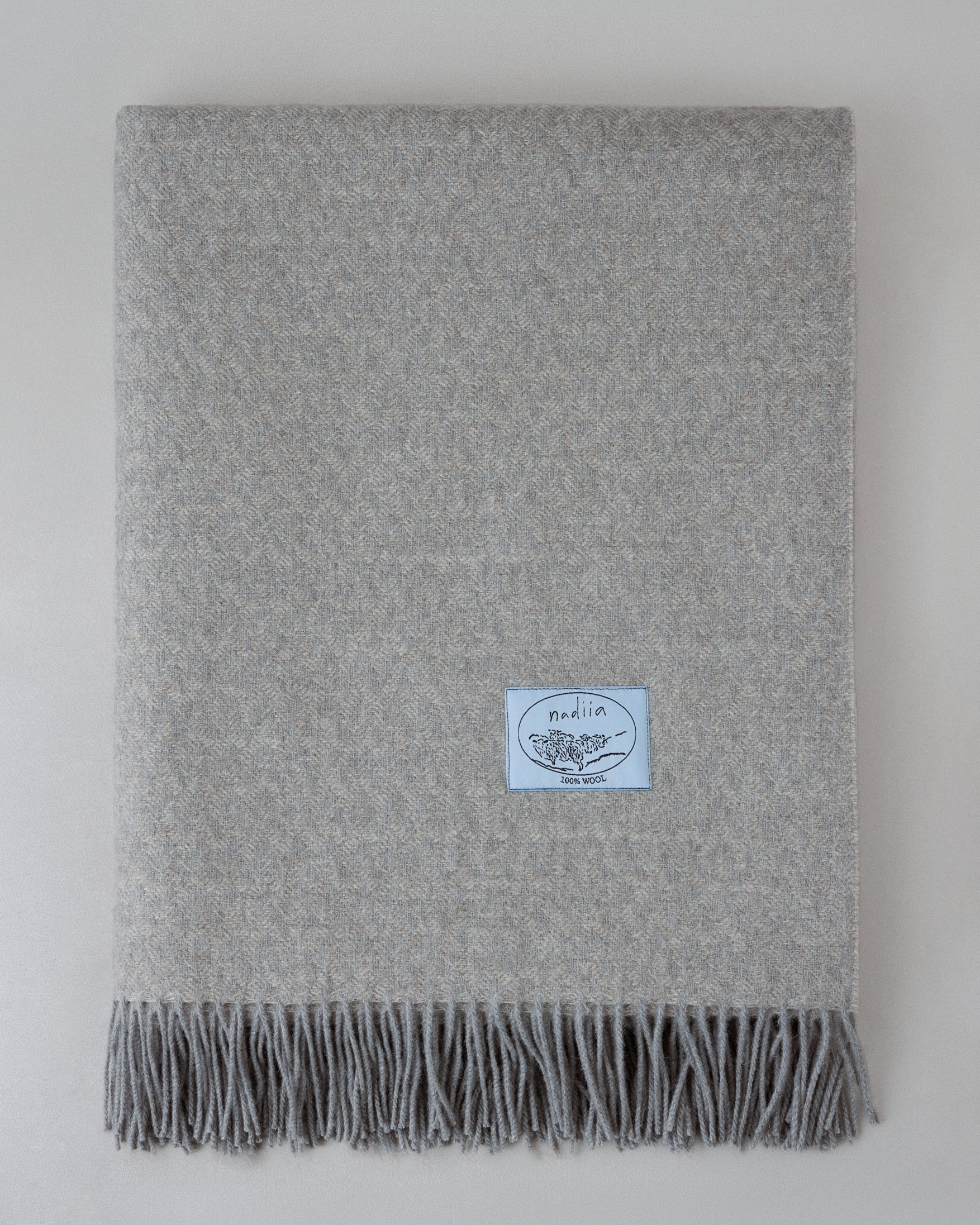 Купіть виріб ручної роботи Pearl Grey Wool Blanket від Nadiia World. Ідеальний вибір для додавання вишуканості та шарму до вашого житлового простору або колекції особистих аксесуарів.