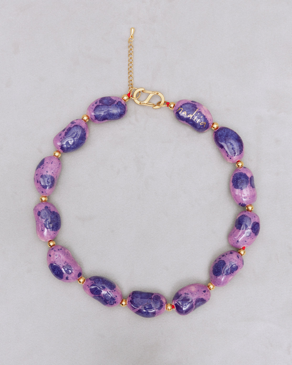 Купіть виріб ручної роботи Purple Speckled "Beans" Necklace від Nadiia World. Ідеальний вибір для додавання вишуканості та шарму до вашого житлового простору або колекції особистих аксесуарів.