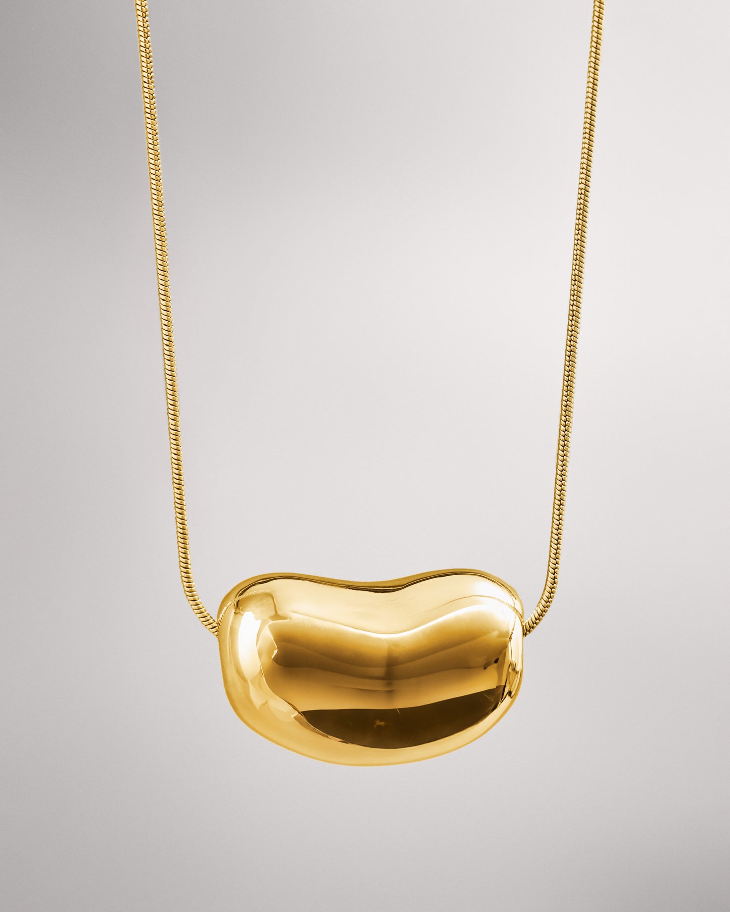 Купіть виріб ручної роботи Golden "Bean" Pendant від Nadiia World. Ідеальний вибір для додавання вишуканості та шарму до вашого житлового простору або колекції особистих аксесуарів.
