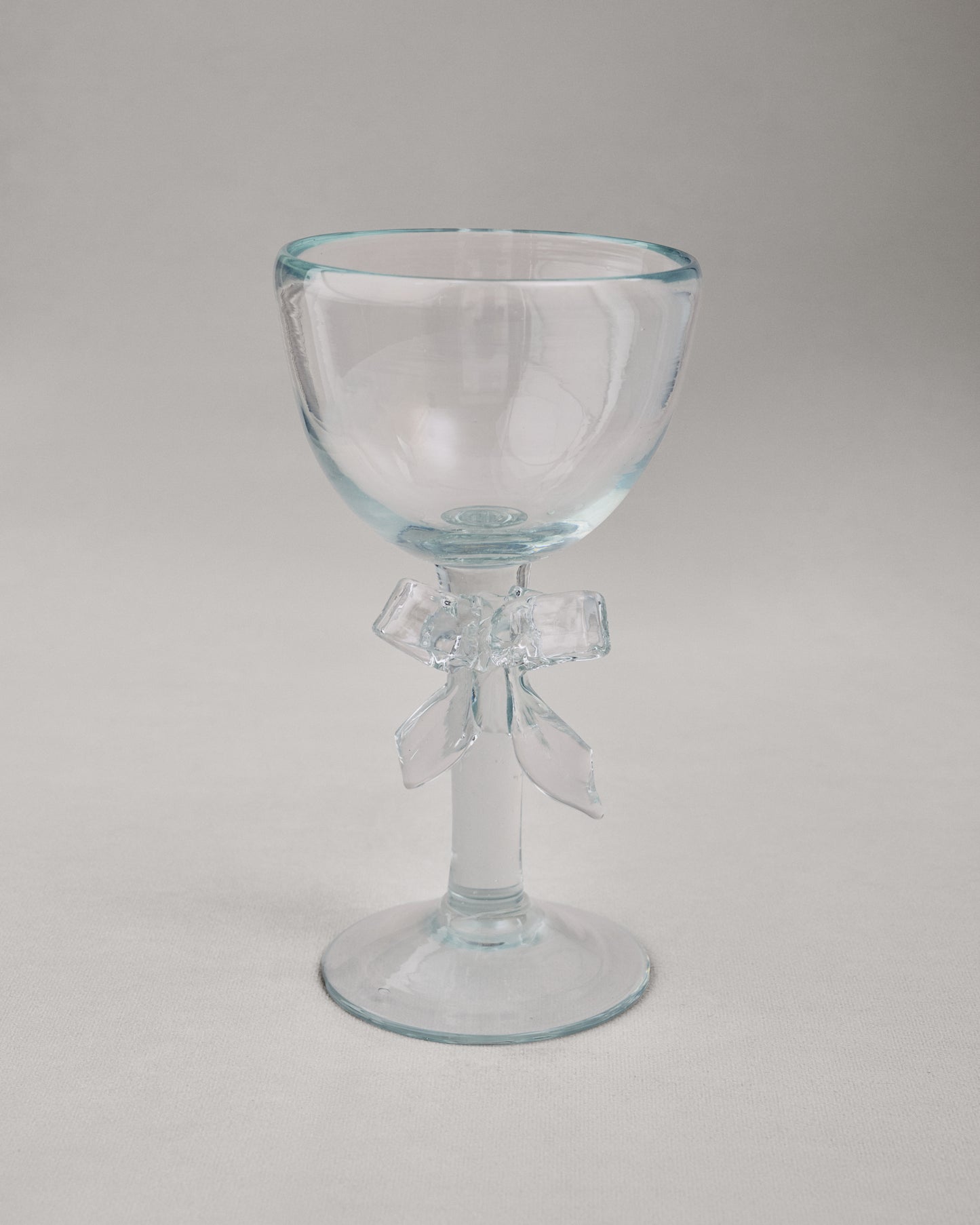 Купіть виріб ручної роботи Transparent Glass Goblet "Bow" від Nadiia World. Ідеальний вибір для додавання вишуканості та шарму до вашого житлового простору або колекції особистих аксесуарів.