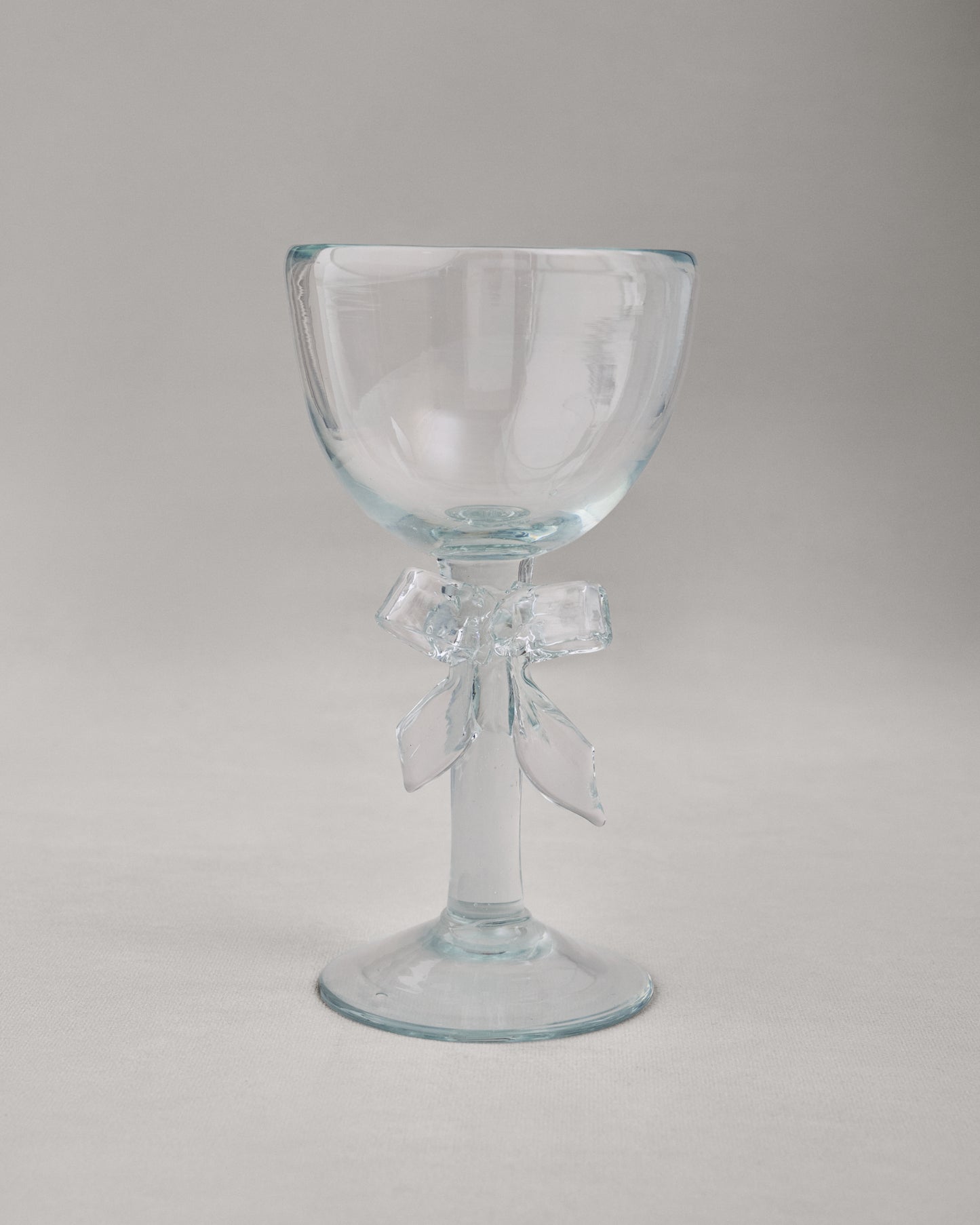Купіть виріб ручної роботи Transparent Glass Goblet "Bow" від Nadiia World. Ідеальний вибір для додавання вишуканості та шарму до вашого житлового простору або колекції особистих аксесуарів.