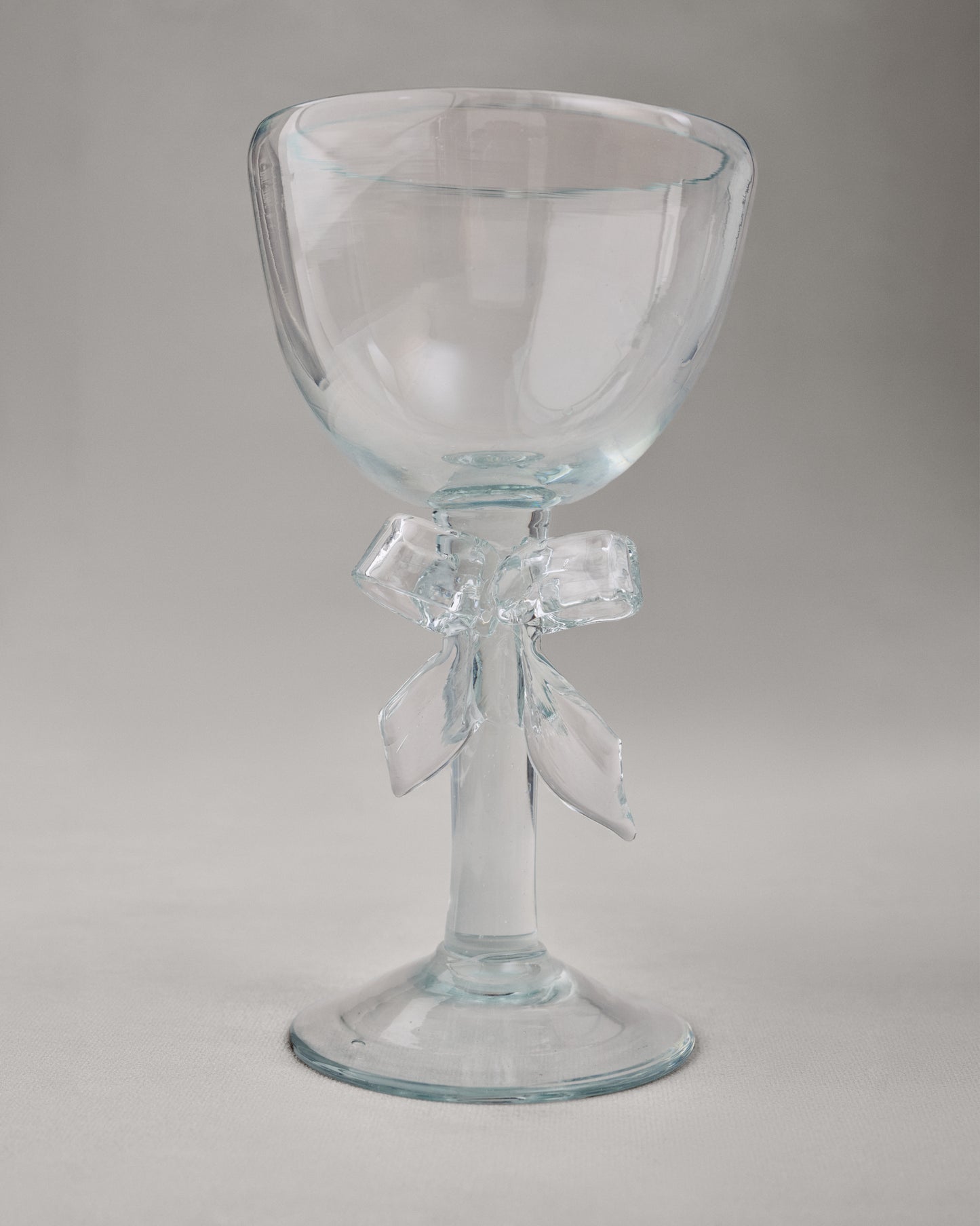 Купіть виріб ручної роботи Transparent Glass Goblet "Bow" від Nadiia World. Ідеальний вибір для додавання вишуканості та шарму до вашого житлового простору або колекції особистих аксесуарів.