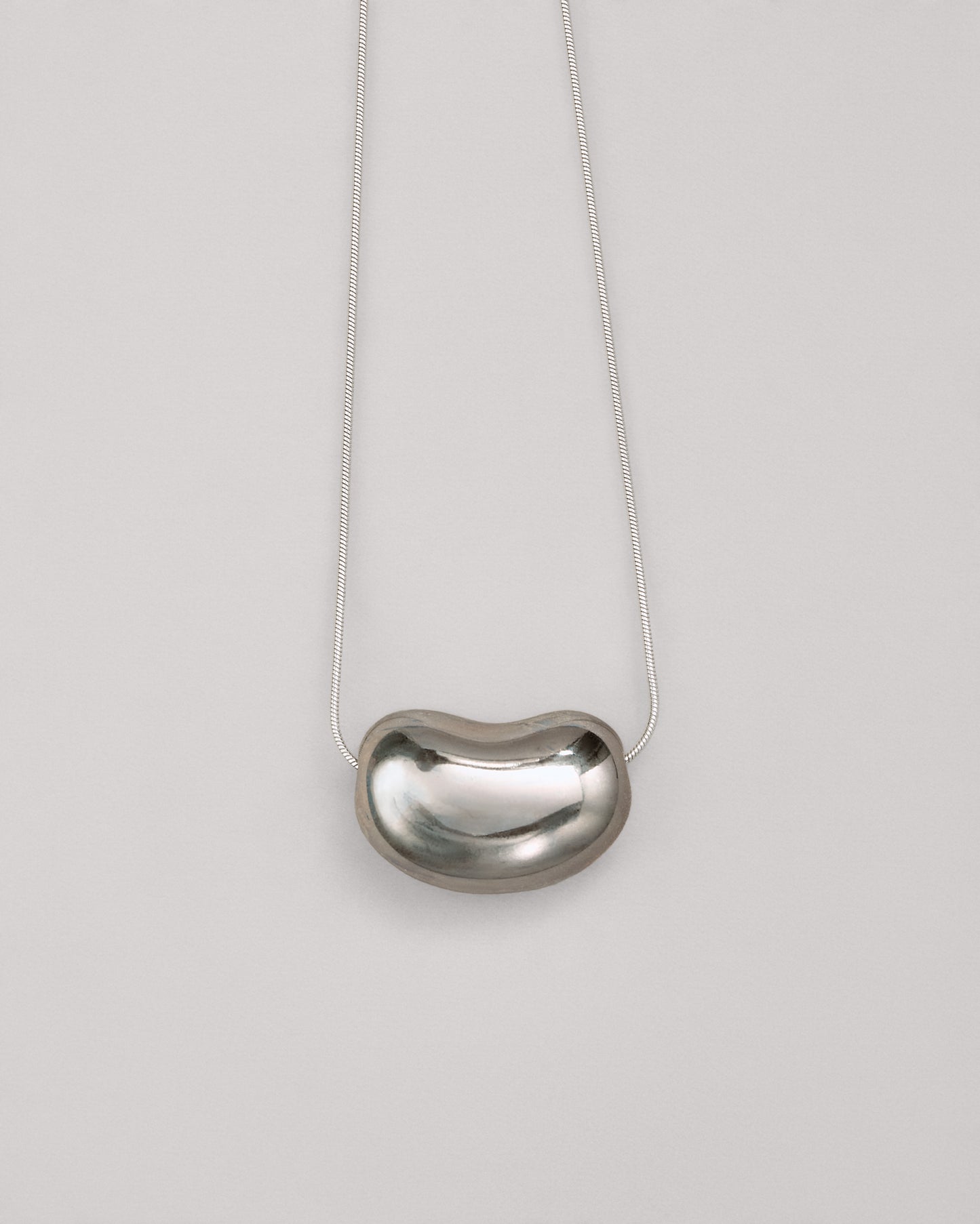 Купіть виріб ручної роботи Silver "Bean" Pendant від Nadiia World. Ідеальний вибір для додавання вишуканості та шарму до вашого житлового простору або колекції особистих аксесуарів.