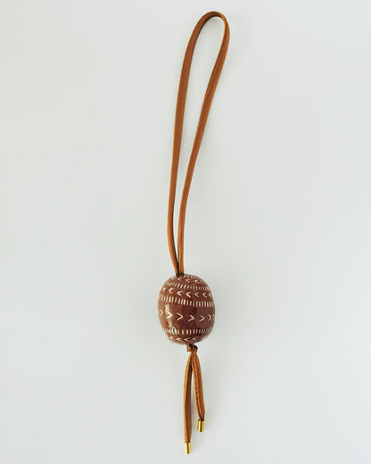 Купіть виріб ручної роботи Bag charm “Brown Pysanka” від Nadiia World. Ідеальний вибір для додавання вишуканості та шарму до вашого житлового простору або колекції особистих аксесуарів.