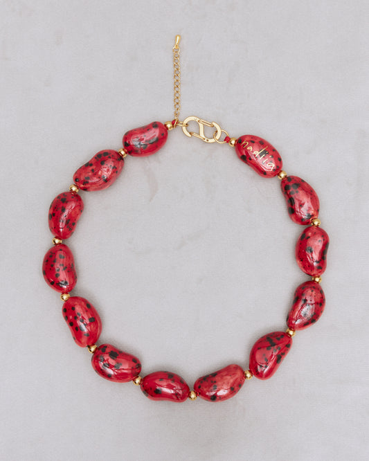 Купіть виріб ручної роботи Red Speckled "Beans" Necklace від Nadiia World. Ідеальний вибір для додавання вишуканості та шарму до вашого житлового простору або колекції особистих аксесуарів.