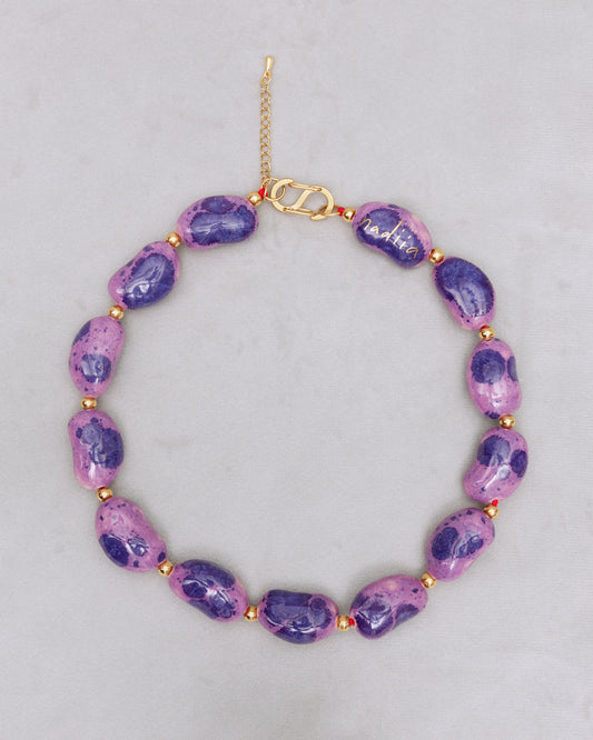 Купіть виріб ручної роботи Purple Speckled "Beans" Necklace від Nadiia World. Ідеальний вибір для додавання вишуканості та шарму до вашого житлового простору або колекції особистих аксесуарів.