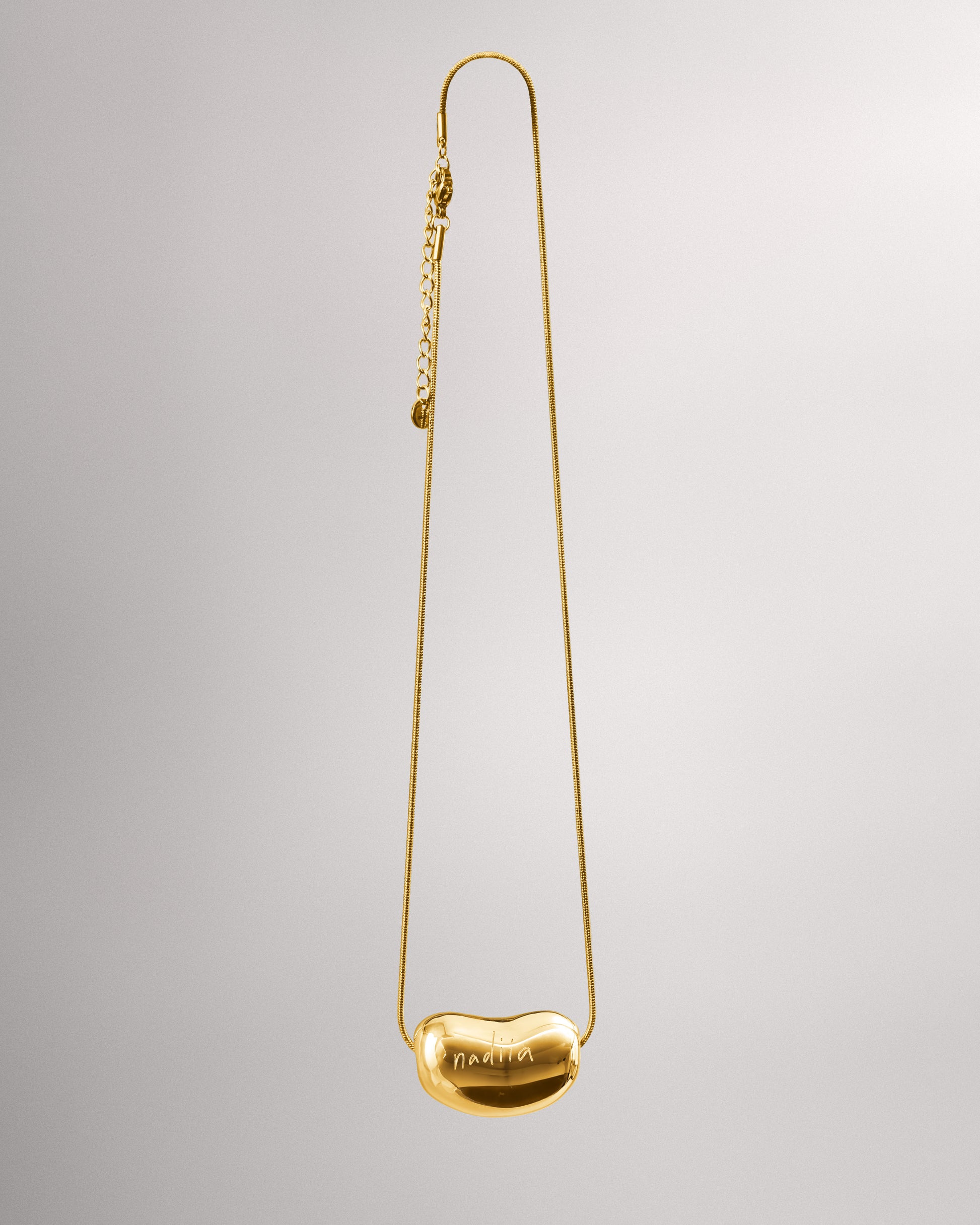 Купіть виріб ручної роботи Golden "Bean" Pendant від Nadiia World. Ідеальний вибір для додавання вишуканості та шарму до вашого житлового простору або колекції особистих аксесуарів.