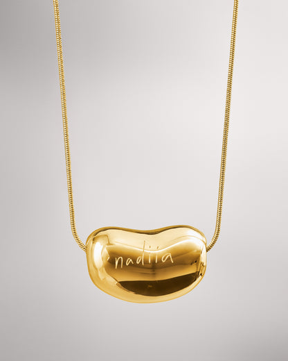 Купіть виріб ручної роботи Golden "Bean" Pendant від Nadiia World. Ідеальний вибір для додавання вишуканості та шарму до вашого житлового простору або колекції особистих аксесуарів.