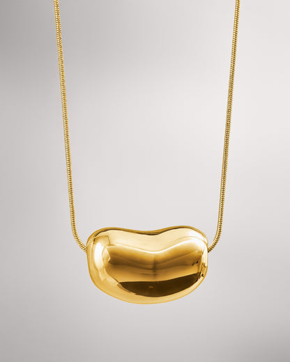 Купіть виріб ручної роботи Golden "Bean" Pendant від Nadiia World. Ідеальний вибір для додавання вишуканості та шарму до вашого житлового простору або колекції особистих аксесуарів.