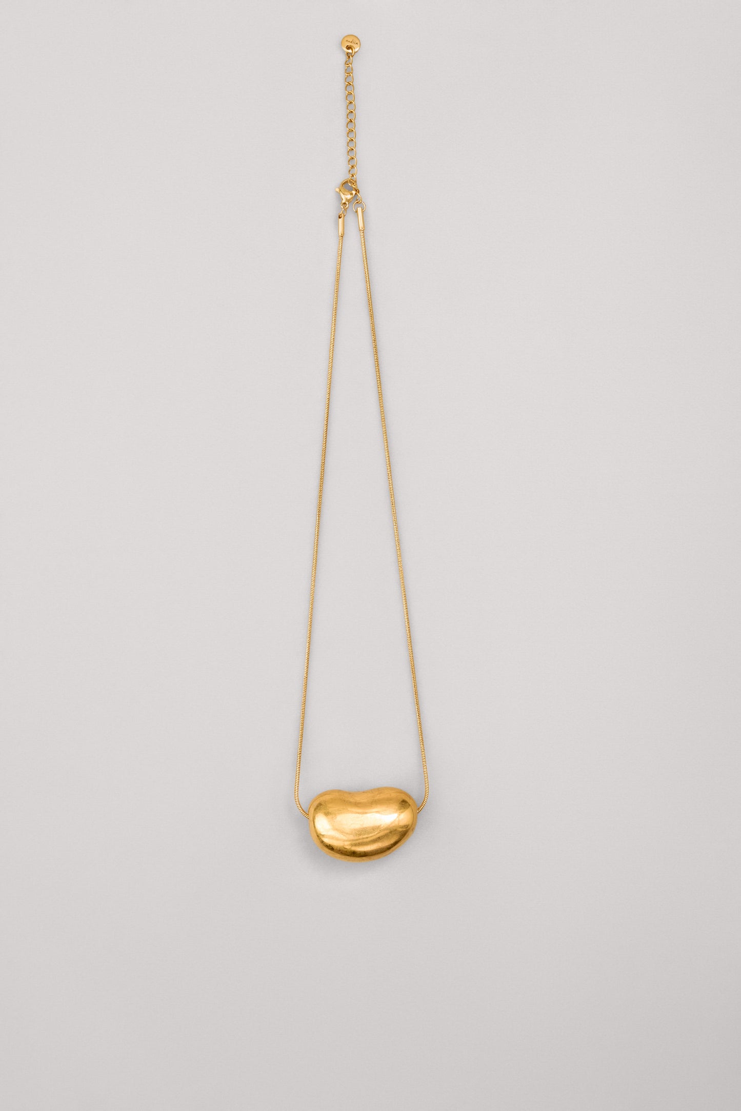 Купіть виріб ручної роботи Golden "Bean" Pendant від Nadiia World. Ідеальний вибір для додавання вишуканості та шарму до вашого житлового простору або колекції особистих аксесуарів.