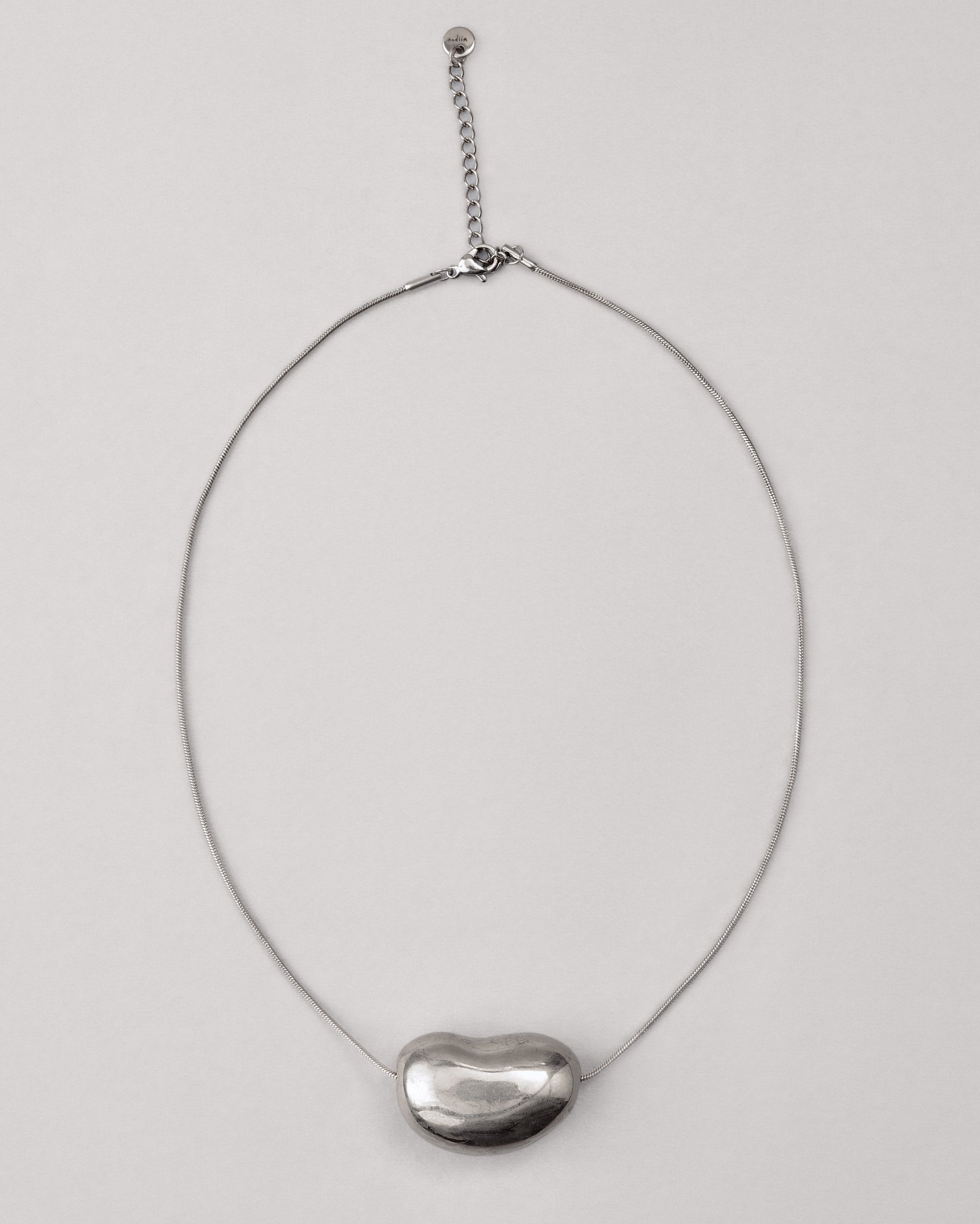 Купіть виріб ручної роботи Silver "Bean" Pendant від Nadiia World. Ідеальний вибір для додавання вишуканості та шарму до вашого житлового простору або колекції особистих аксесуарів.
