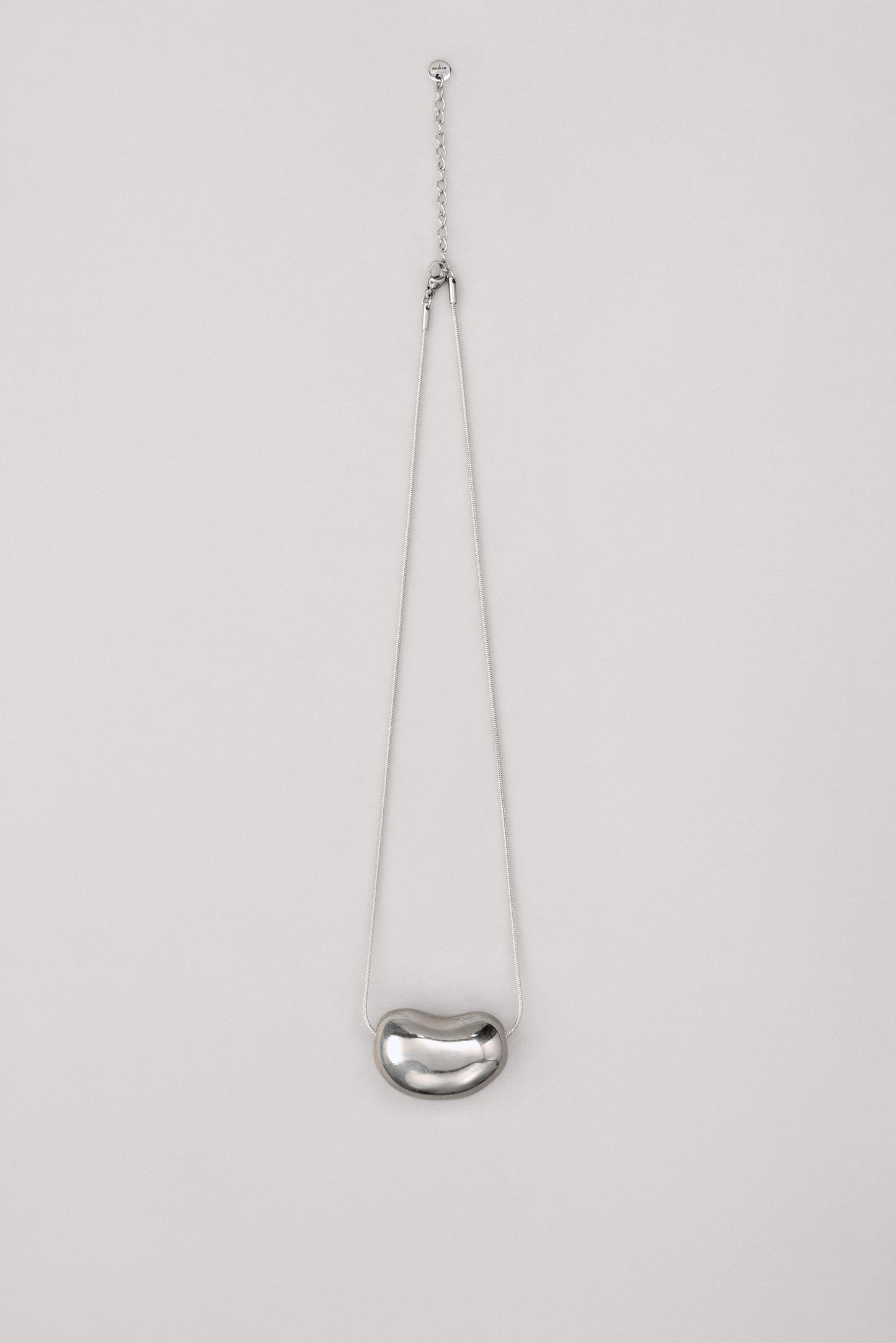 Купіть виріб ручної роботи Silver "Bean" Pendant від Nadiia World. Ідеальний вибір для додавання вишуканості та шарму до вашого житлового простору або колекції особистих аксесуарів.