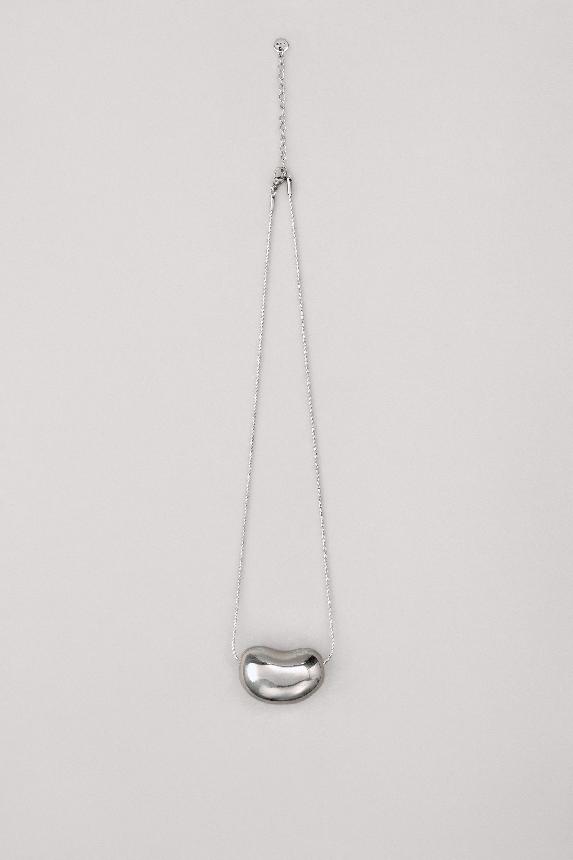 Купіть виріб ручної роботи Silver "Bean" Pendant від Nadiia World. Ідеальний вибір для додавання вишуканості та шарму до вашого житлового простору або колекції особистих аксесуарів.