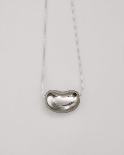 Купіть виріб ручної роботи Silver "Bean" Pendant від Nadiia World. Ідеальний вибір для додавання вишуканості та шарму до вашого житлового простору або колекції особистих аксесуарів.