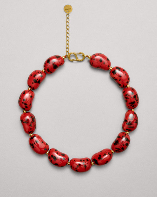 Купіть виріб ручної роботи Red Speckled "Beans" Necklace від Nadiia World. Ідеальний вибір для додавання вишуканості та шарму до вашого житлового простору або колекції особистих аксесуарів.