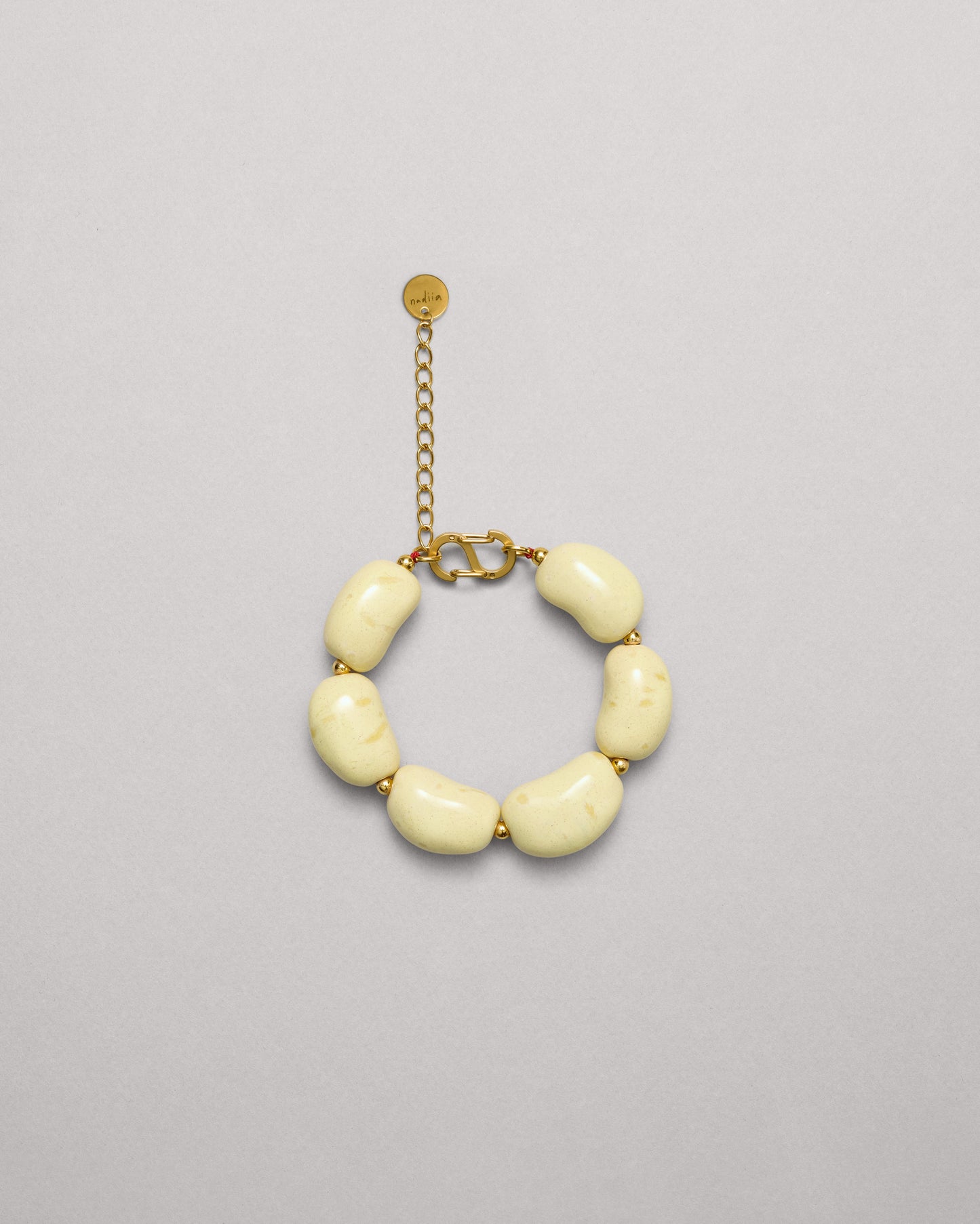 Купіть виріб ручної роботи Yellow Speckled "Beans" Bracelet від Nadiia World. Ідеальний вибір для додавання вишуканості та шарму до вашого житлового простору або колекції особистих аксесуарів.