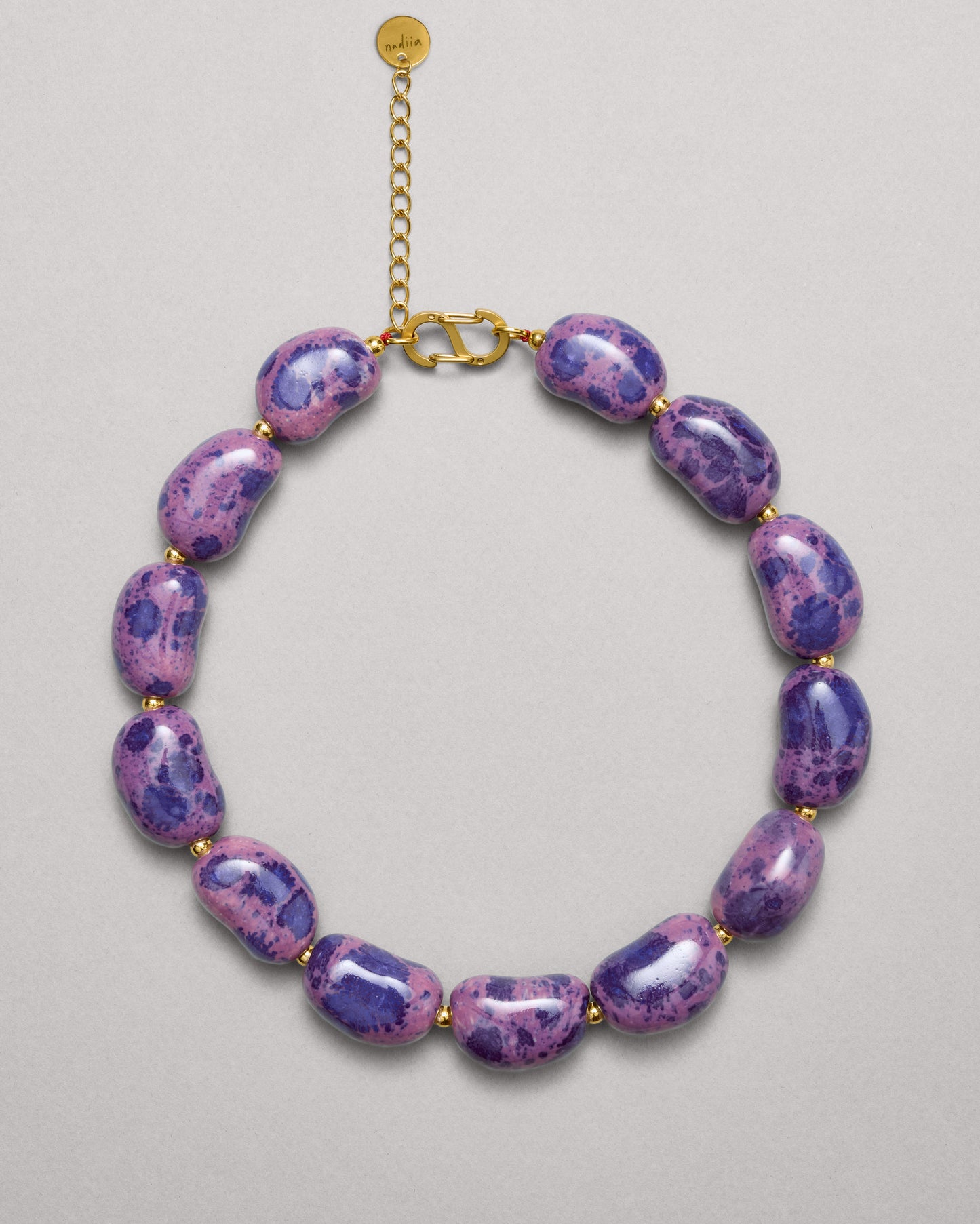 Купіть виріб ручної роботи Purple Speckled "Beans" Necklace від Nadiia World. Ідеальний вибір для додавання вишуканості та шарму до вашого житлового простору або колекції особистих аксесуарів.