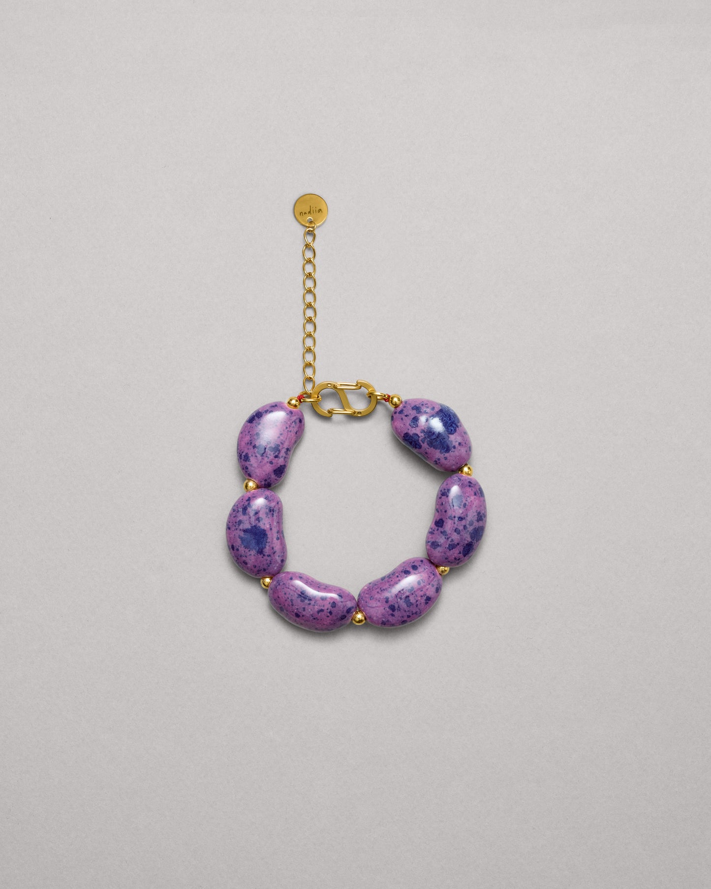 Купіть виріб ручної роботи Purple Speckled "Beans" Bracelet від Nadiia World. Ідеальний вибір для додавання вишуканості та шарму до вашого житлового простору або колекції особистих аксесуарів.