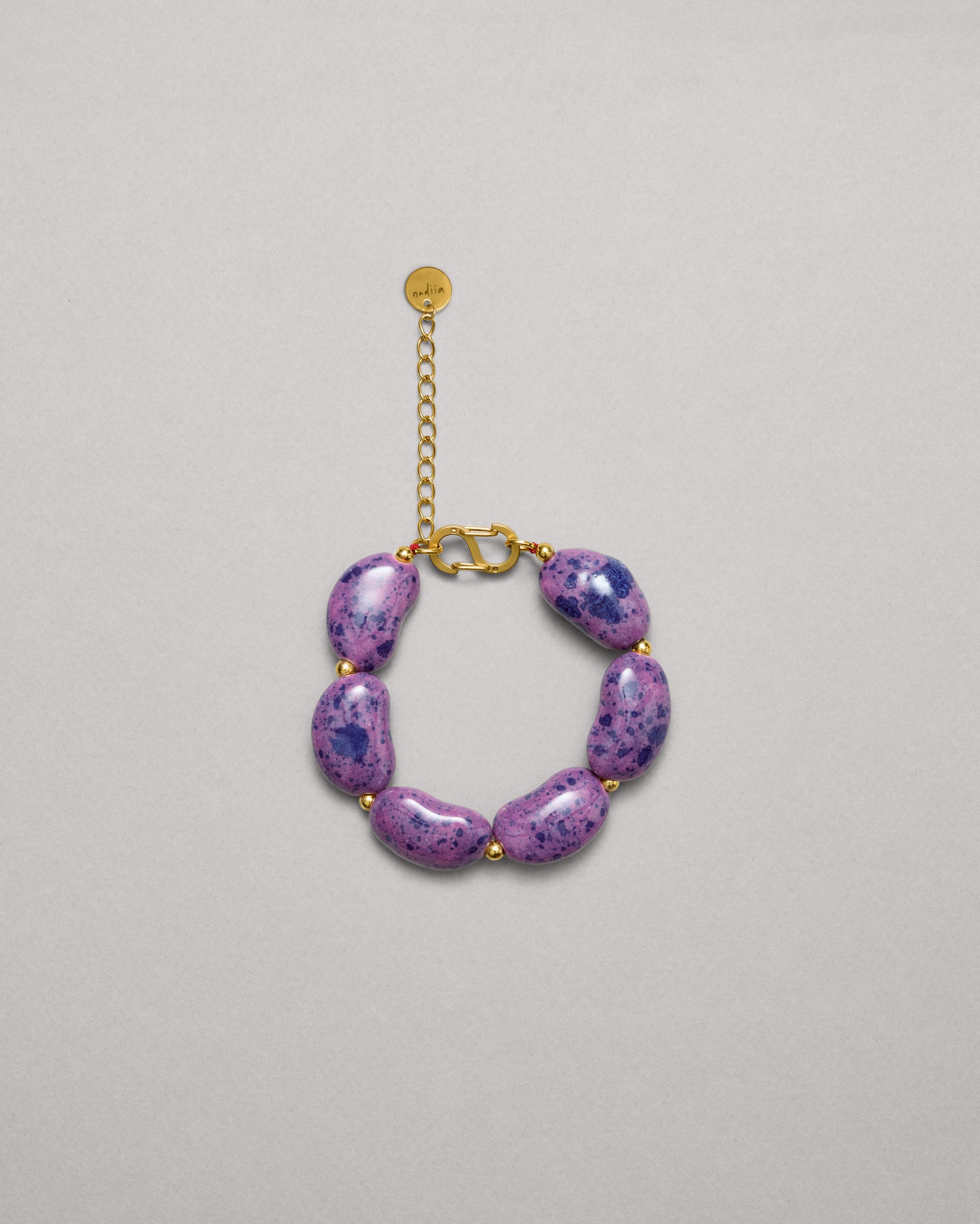 Купіть виріб ручної роботи Purple Speckled "Beans" Bracelet від Nadiia World. Ідеальний вибір для додавання вишуканості та шарму до вашого житлового простору або колекції особистих аксесуарів.