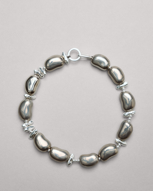 Купіть виріб ручної роботи Futuristic Silver "Beans" Necklace від Nadiia World. Ідеальний вибір для додавання вишуканості та шарму до вашого житлового простору або колекції особистих аксесуарів.