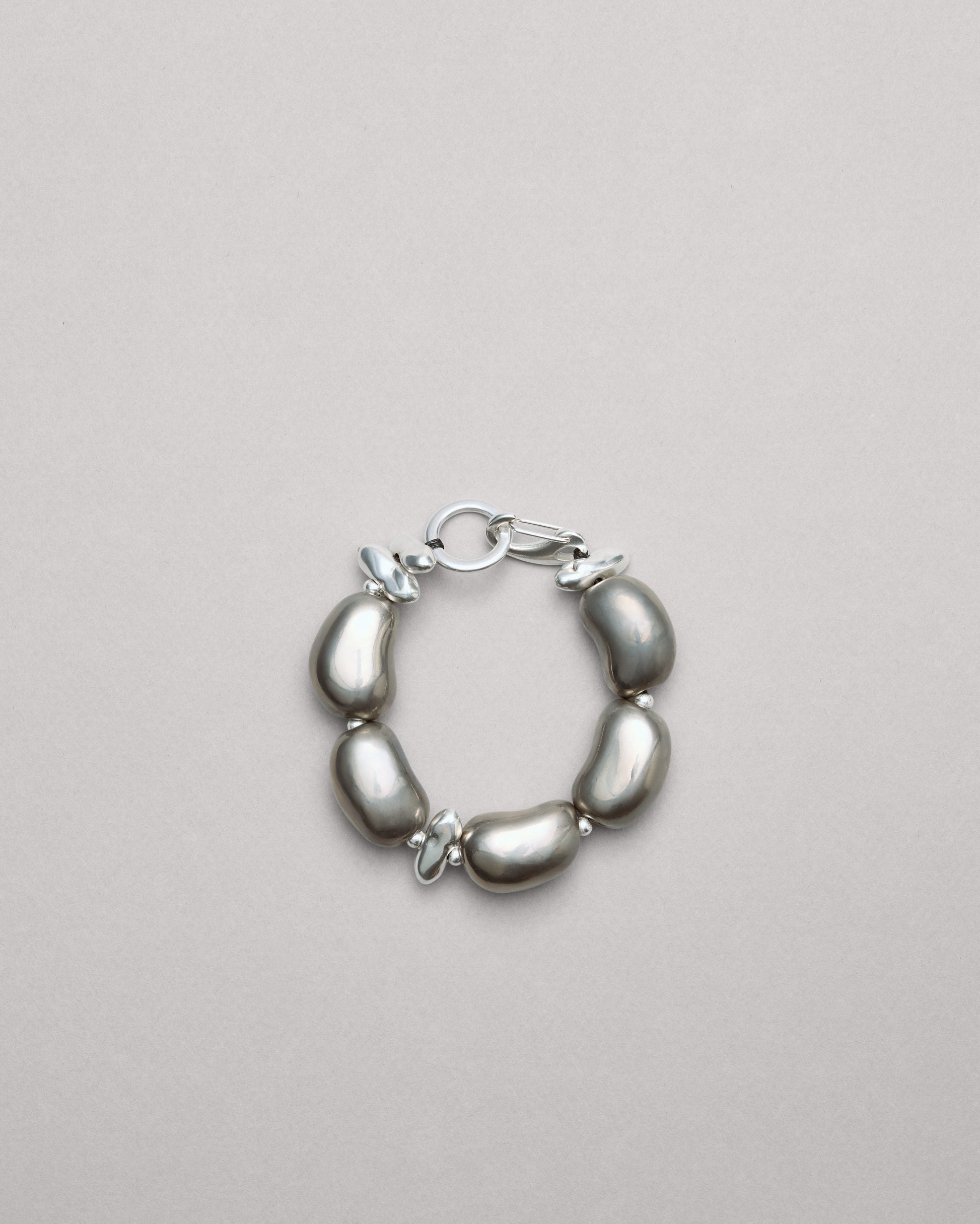 Купіть виріб ручної роботи Futuristic Silver "Beans" Bracelet від Nadiia World. Ідеальний вибір для додавання вишуканості та шарму до вашого житлового простору або колекції особистих аксесуарів.